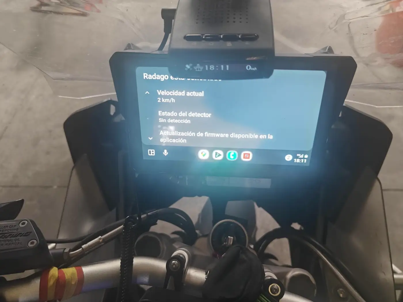 RADAGO EVO montado en el manillar de una moto, con la app RADAGO mostrando velocidad y estado del detector en una pantalla Android Auto